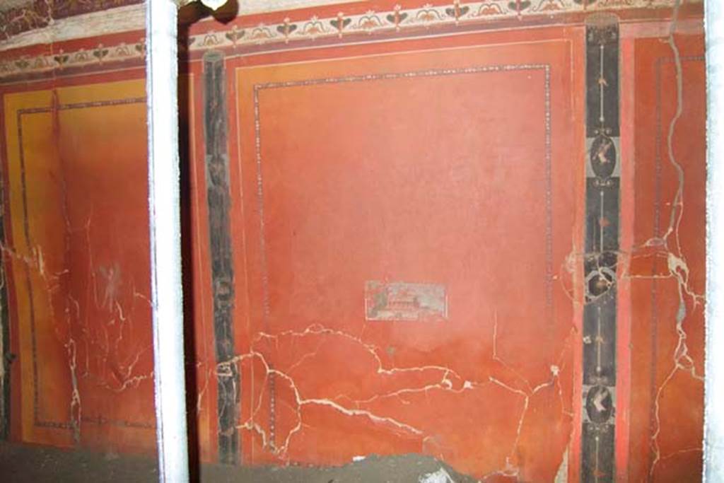 Villa dei Papiri, Herculaneum. July 2010. Room (I) on lower terrace, lower south wall. The short walls like this one have three panels and the long walls have 5 panels. The original yellow background, visible here, has turned red because of the dehydration that the exceptional temperature of the eruption caused.
The centre of this wall is decorated with a small villa scene and on either side are vignettes with flying cupids.
Photo courtesy of Michael Binns.
See Esposito D. and Guidobaldi M., 2010. New Archaeological Research at the Villa of the Papyri, in the Villa of the Papyri at Herculaneum. Berlin: De Gruyter, p. 35.